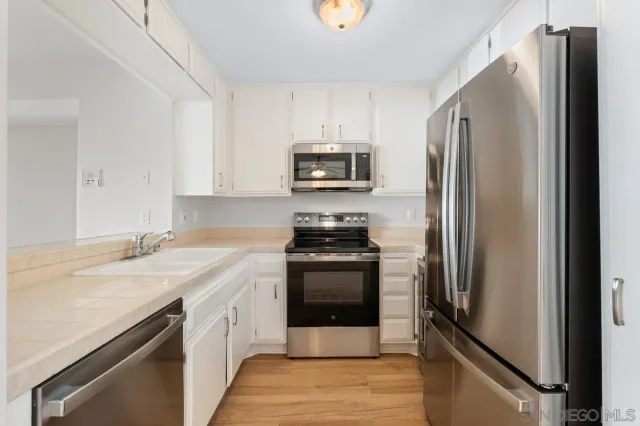 a kitchen with stainless steel appliances a stove microwave and sink