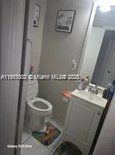 a bathroom with a sink toilet and a mirror