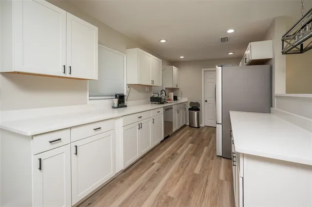 a large kitchen with kitchen island a sink stainless steel appliances and cabinets