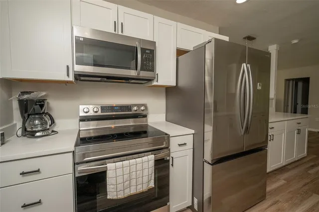 a kitchen with stainless steel appliances a stove a microwave and a refrigerator