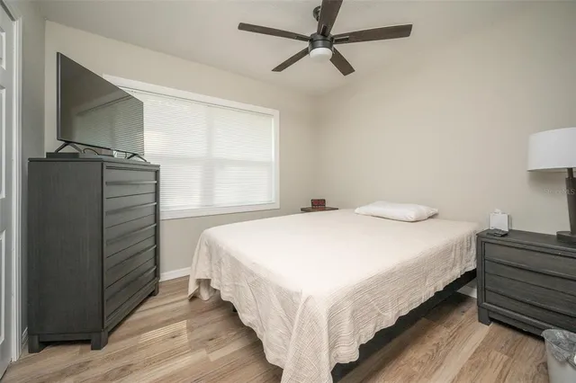 a bedroom with a bed and a flat tv screen on dresser
