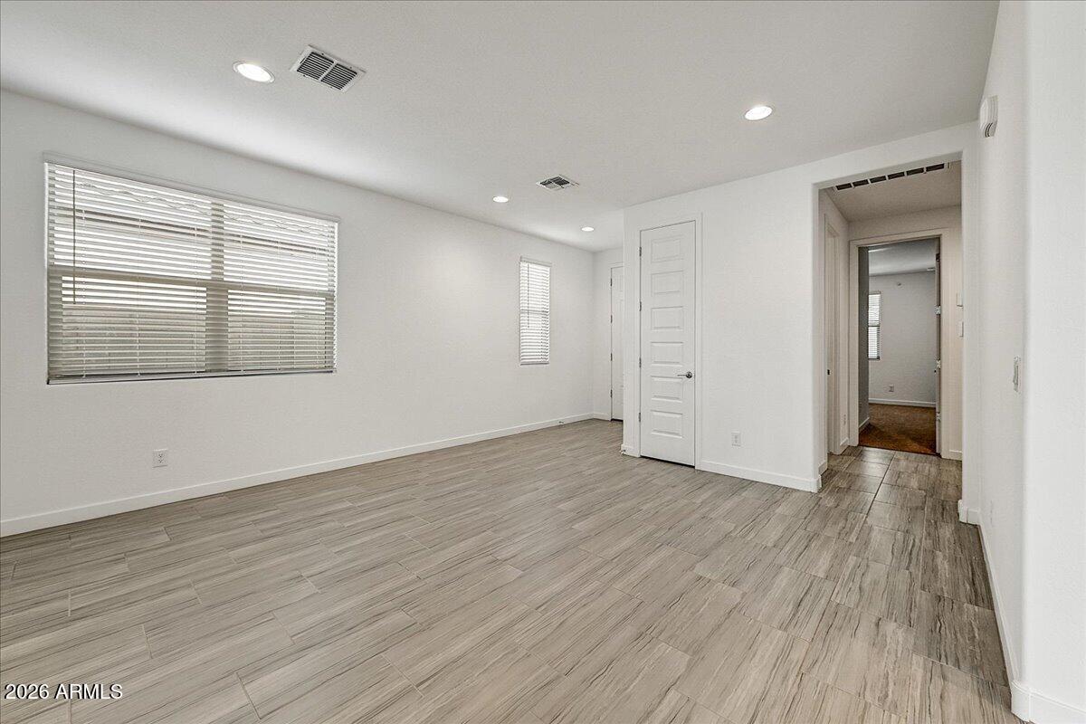1642 West Monte Way Phoenix, AZ 85041 - Photo 4 of 20 an empty room with wooden floor and windows