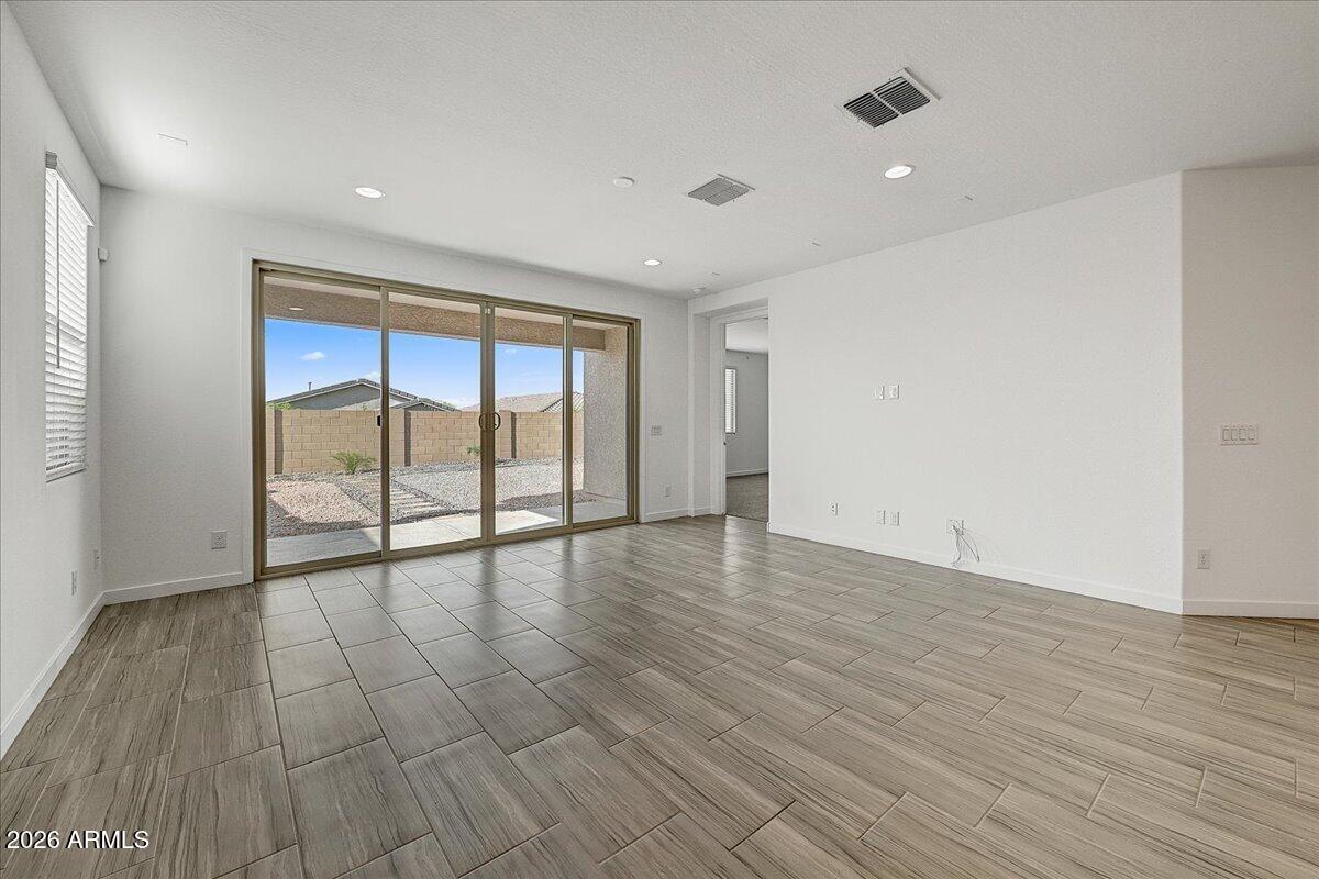 1642 West Monte Way Phoenix, AZ 85041 - Photo 6 of 20 a view of an empty room with wooden floor and a window