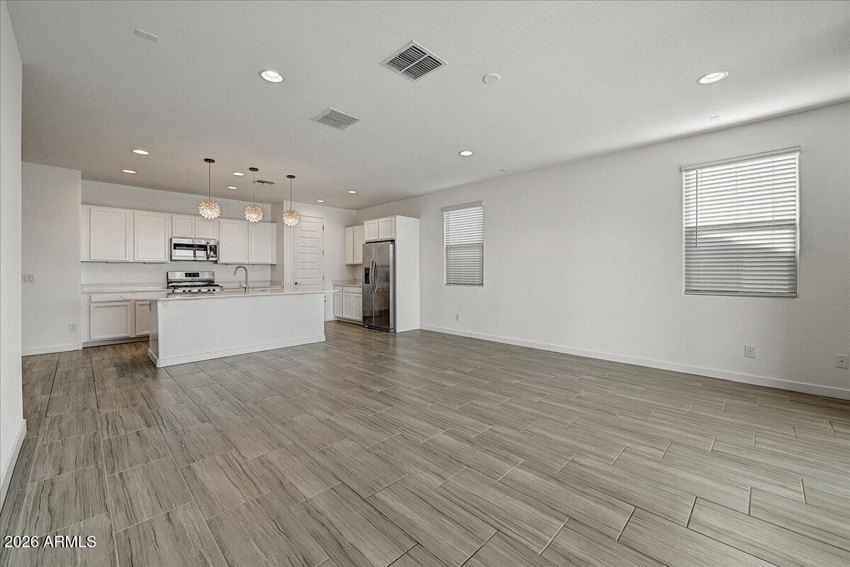 1642 West Monte Way Phoenix, AZ 85041 - Photo 7 of 20 a view of an empty room with wooden floor and a window