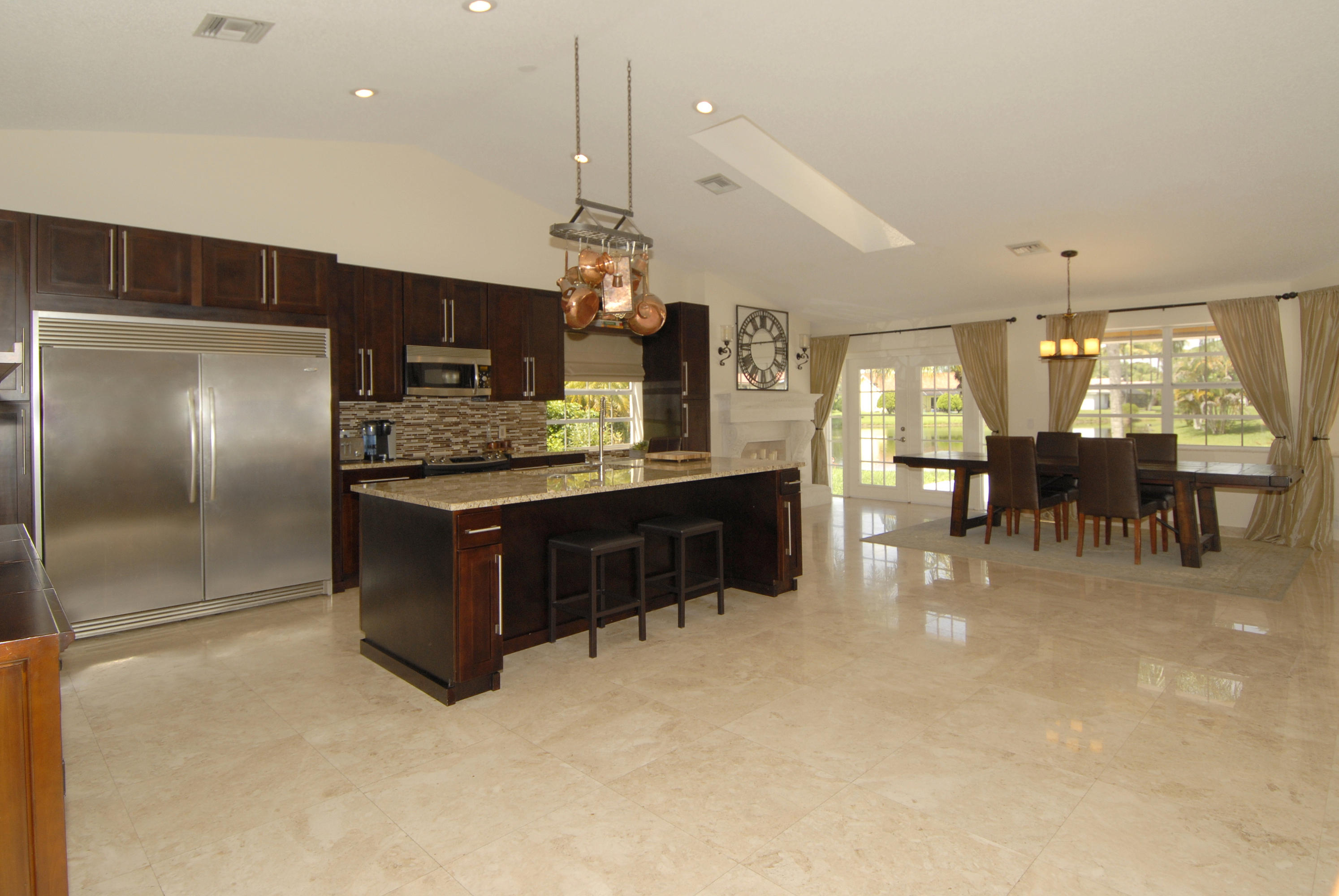 21347 Chinaberry Drive Boca Raton, FL 33428 - Photo 7 of 35 a kitchen with stainless steel appliances kitchen island granite countertop a table and chairs in it