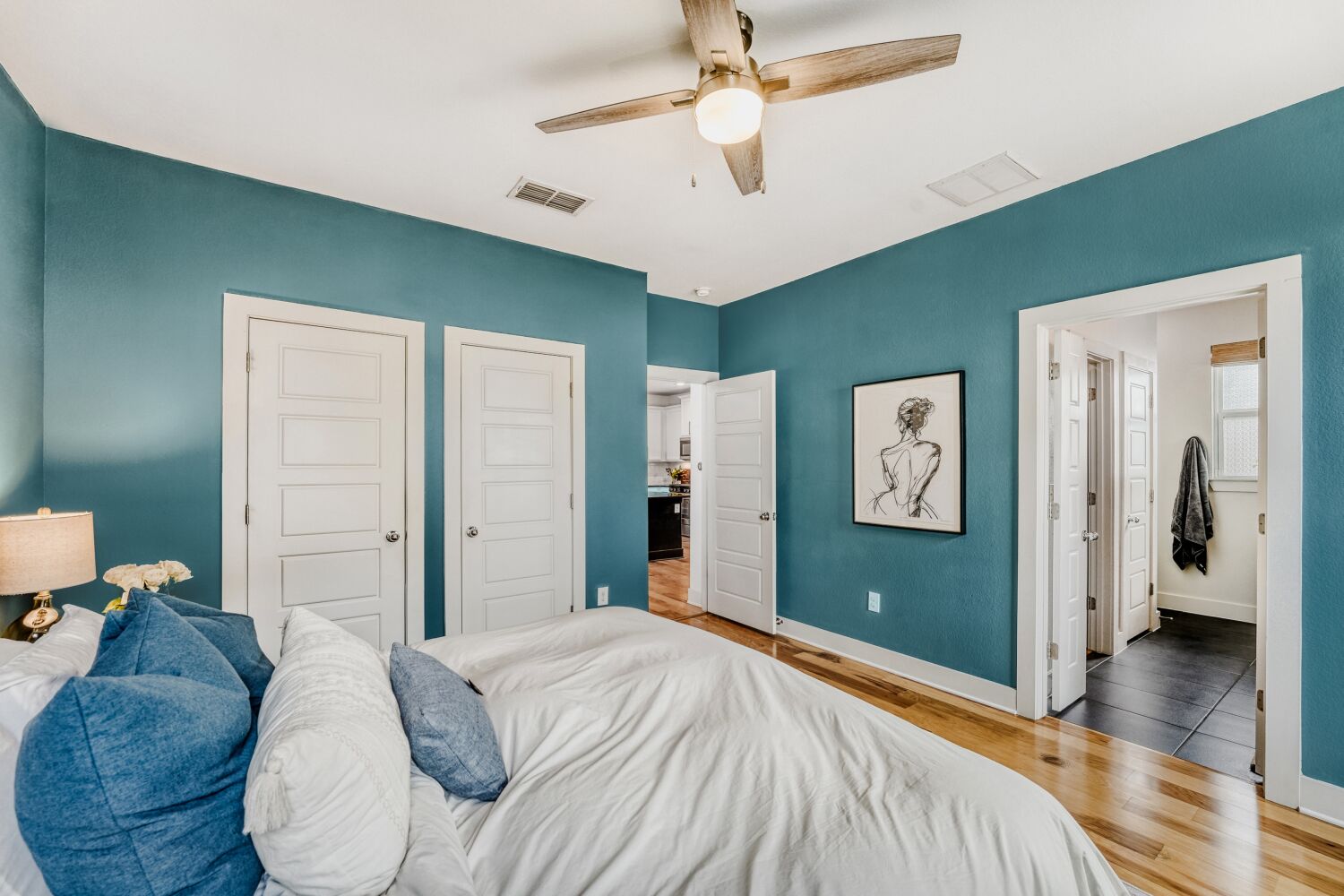 2000 Hermia Street Austin, TX 78741 - Photo 12 of 28 Bedroom featuring wood finished floors, a ceiling fan, and ensuite bathroom
