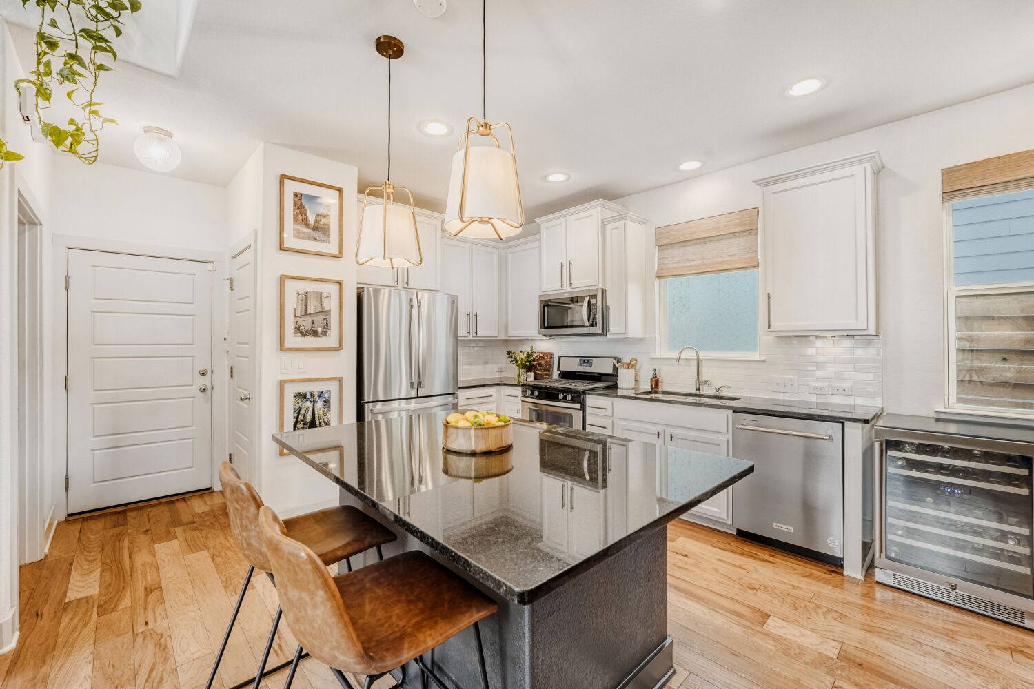 2000 Hermia Street Austin, TX 78741 - Photo 7 of 28 Kitchen featuring wine cooler, stainless steel appliances, dark stone countertops, light wood finished floors, and pendant lighting