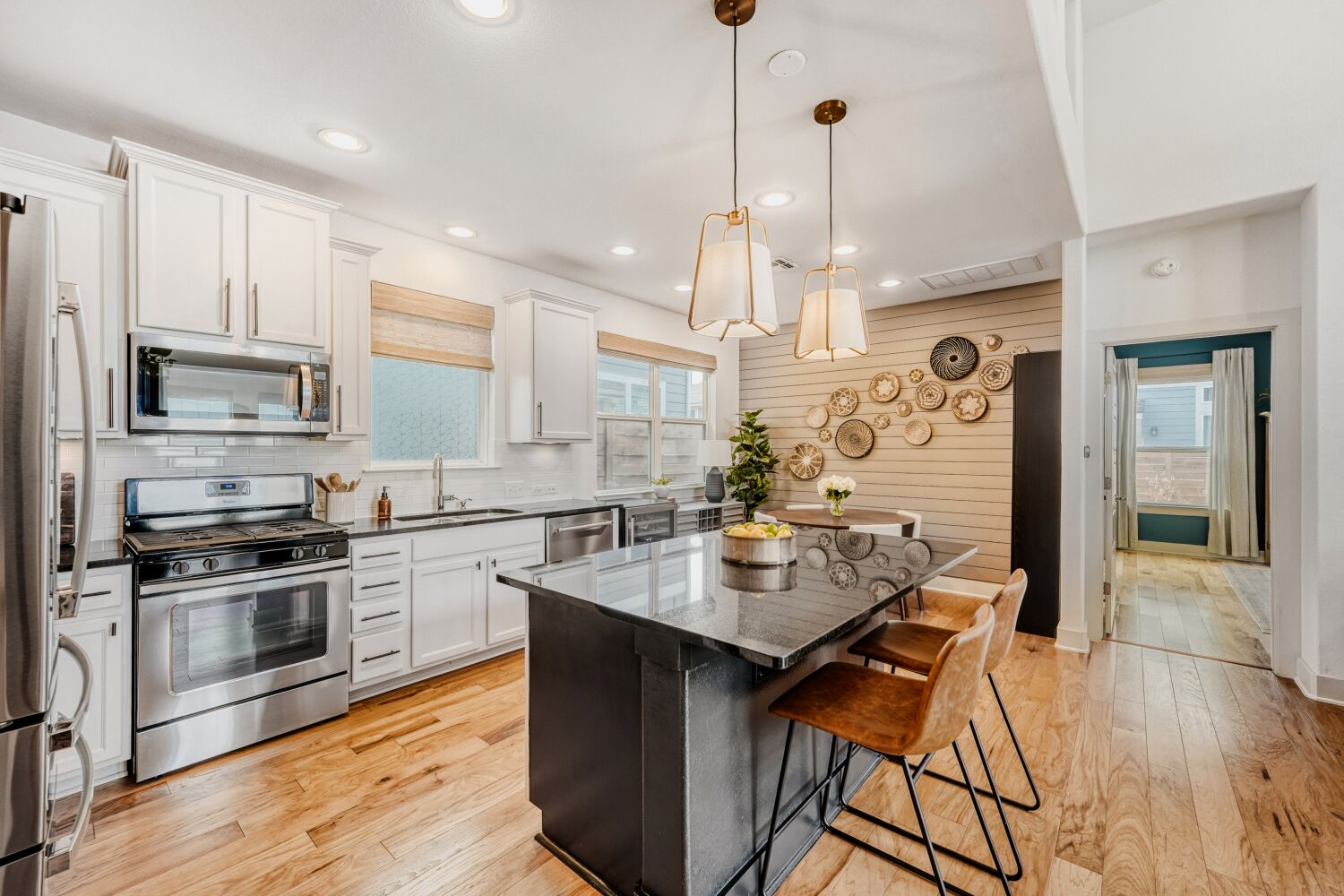 2000 Hermia Street Austin, TX 78741 - Photo 8 of 28 Kitchen featuring stainless steel appliances, a breakfast bar, light wood-style flooring, a center island, and white cabinets