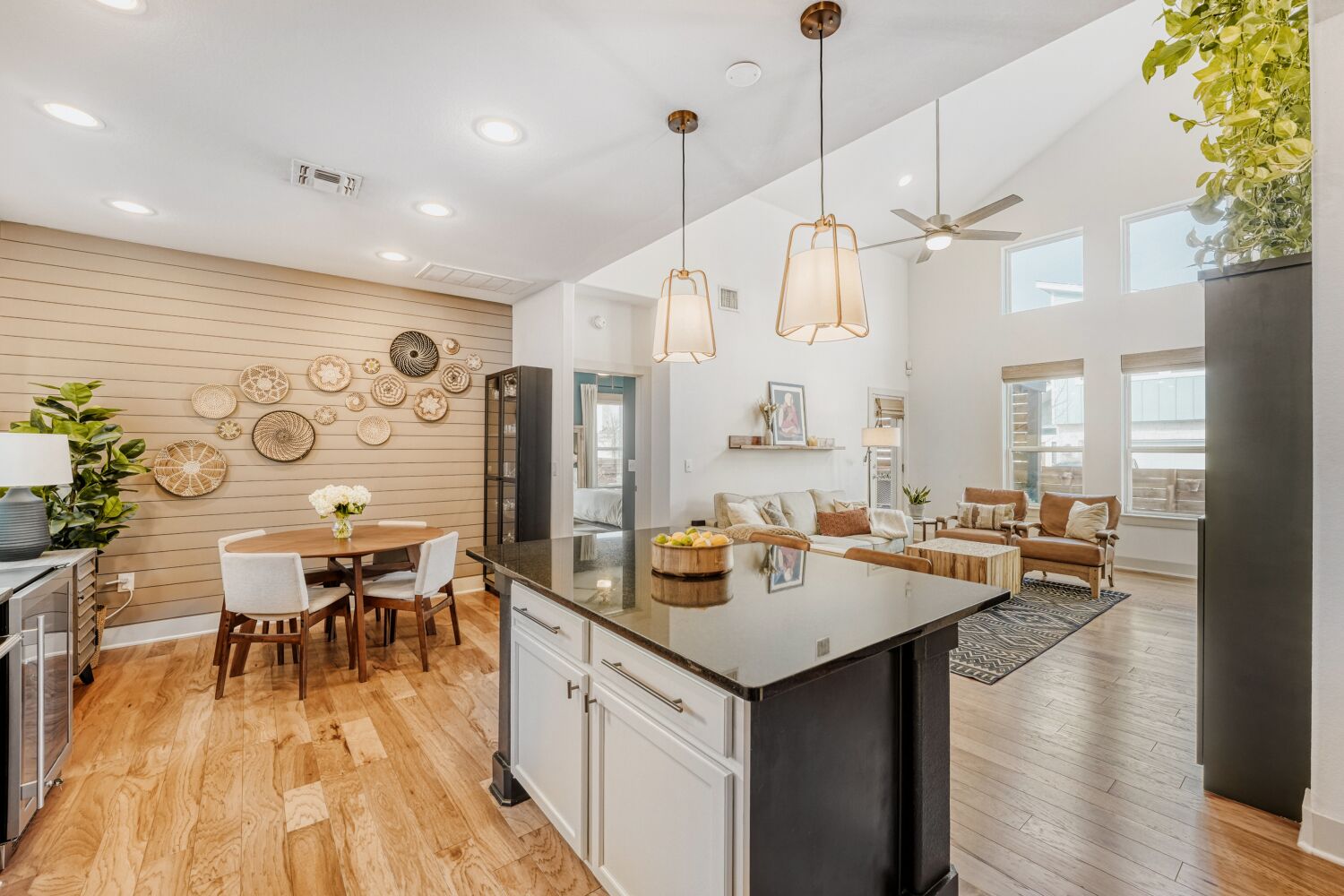 2000 Hermia Street Austin, TX 78741 - Photo 28 of 28 Kitchen with light wood finished floors, decorative light fixtures, white cabinets, open floor plan, and a kitchen island