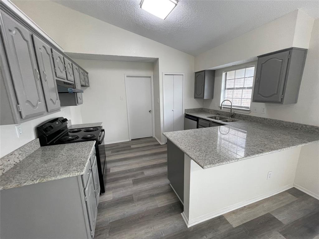 9415 Rutherglen Drive Dallas, TX 75227 - Photo 7 of 18 a kitchen with granite countertop a sink a stove and refrigerator