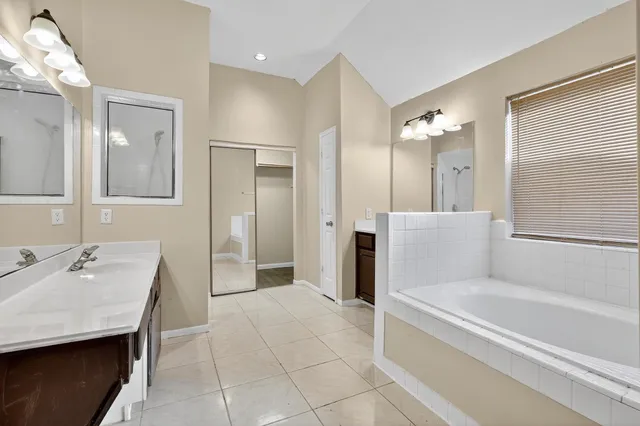 a spacious bathroom with a tub shower and sink