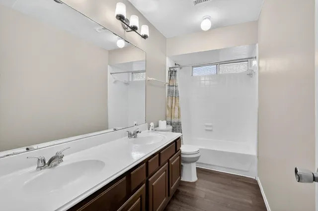 a bathroom with a double vanity sink mirror double and toilet