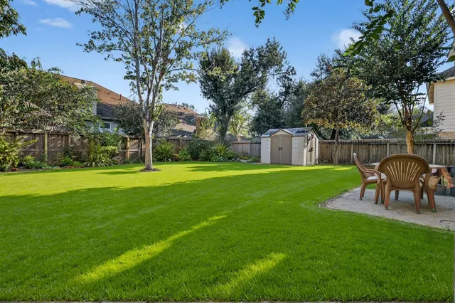 a view of a house with backyard and a patio
