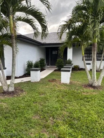 a view of a house with a patio and a yard