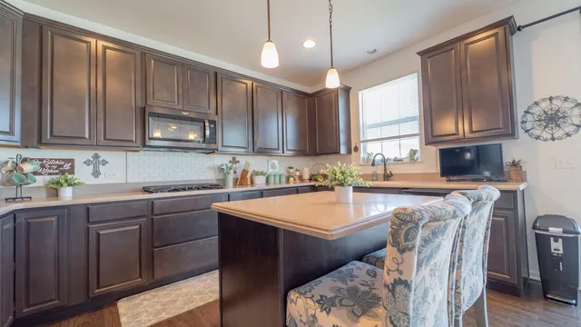 a kitchen with stainless steel appliances granite countertop a sink window and cabinets