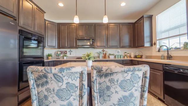 a kitchen with stainless steel appliances kitchen island granite countertop a sink and cabinets