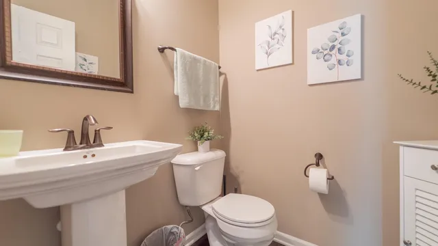 a bathroom with a toilet sink and mirror