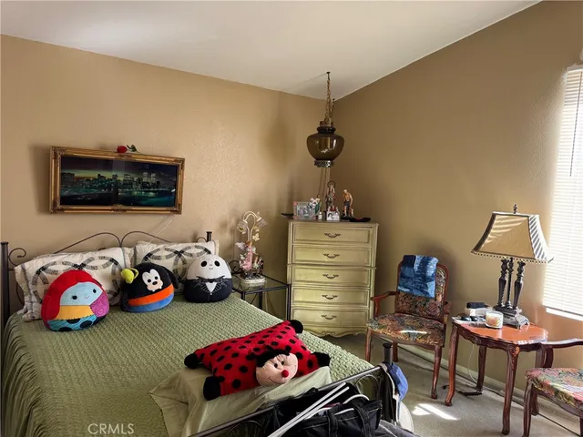 a bedroom with a bed window and a chair