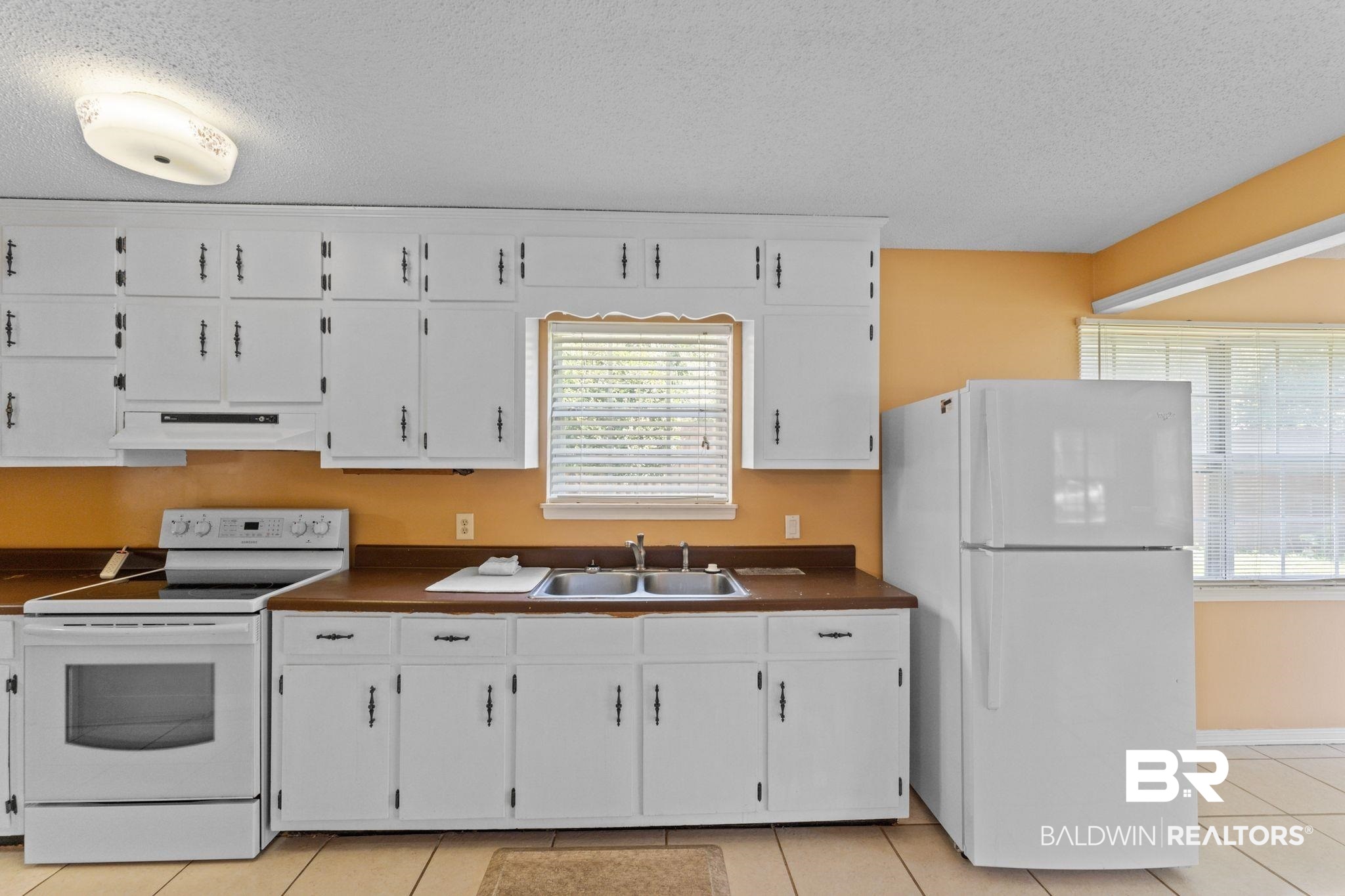 14095 Riverside Drive Foley, AL 36535 - Photo 12 of 30 Kitchen with white appliances, a textured ceiling, dark countertops, and white cabinetry