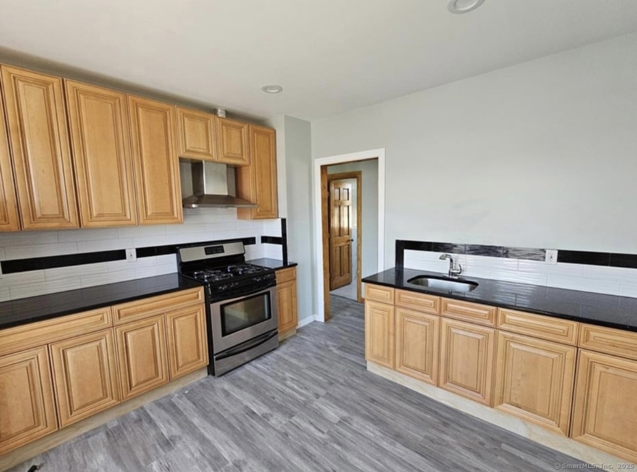 704 Central Avenue, Unit 3 Bridgeport, CT 06607 - Photo 1 of 1 a kitchen with wooden cabinets and stainless steel appliances