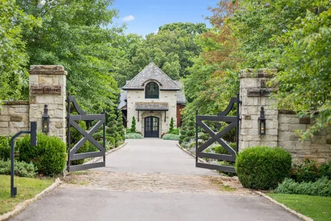 a front view of a house with a garden and fountain