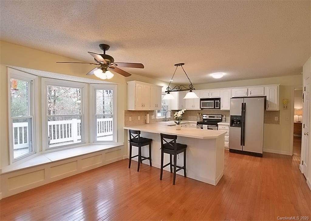 11068 Deep Cove Drive Tega Cay, SC 29708 - Photo 15 of 34 a kitchen with stainless steel appliances kitchen island hardwood floor and a window