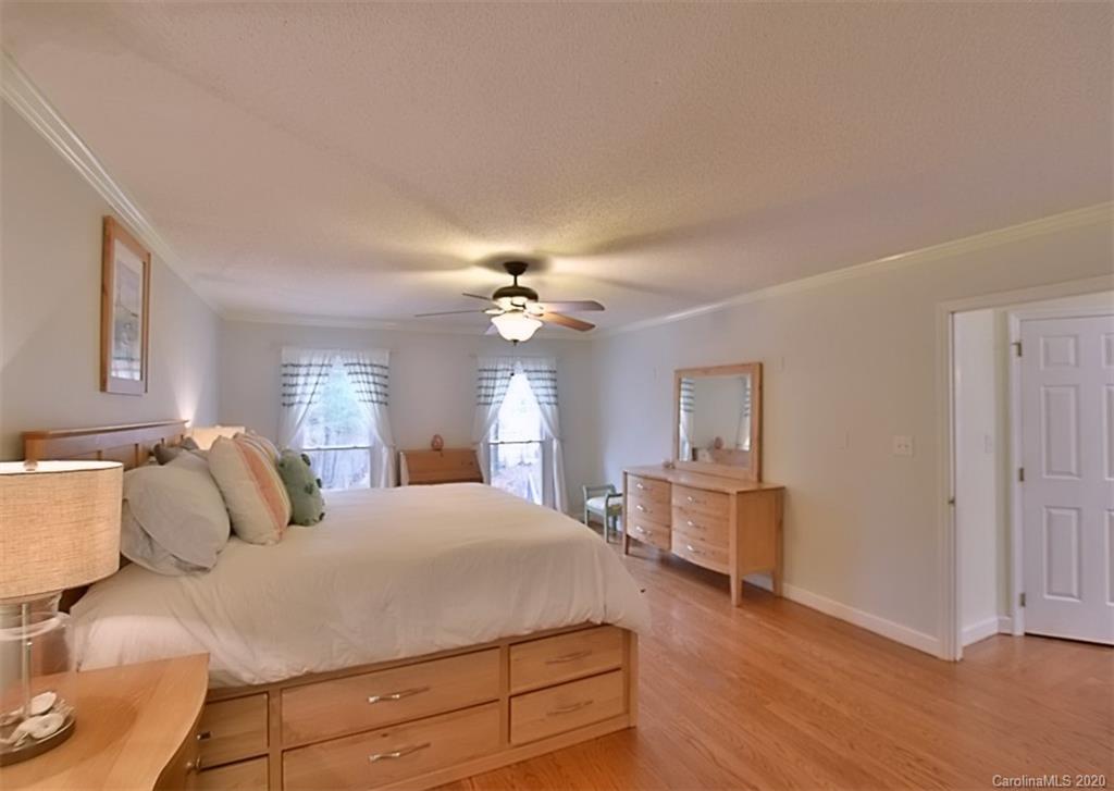 11068 Deep Cove Drive Tega Cay, SC 29708 - Photo 20 of 34 a bedroom with a large bed and a chandelier