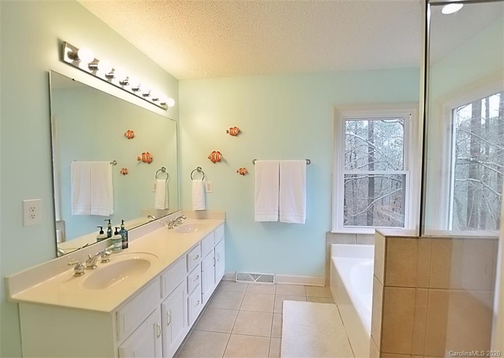 11068 Deep Cove Drive Tega Cay, SC 29708 - Photo 21 of 34 a spacious bathroom with a double vanity sink mirror and bathtub