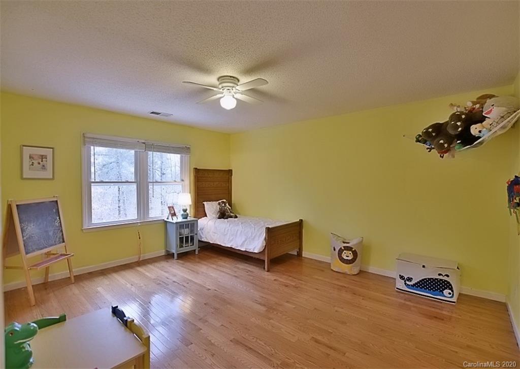 11068 Deep Cove Drive Tega Cay, SC 29708 - Photo 25 of 34 a bedroom with a bed and wooden floor