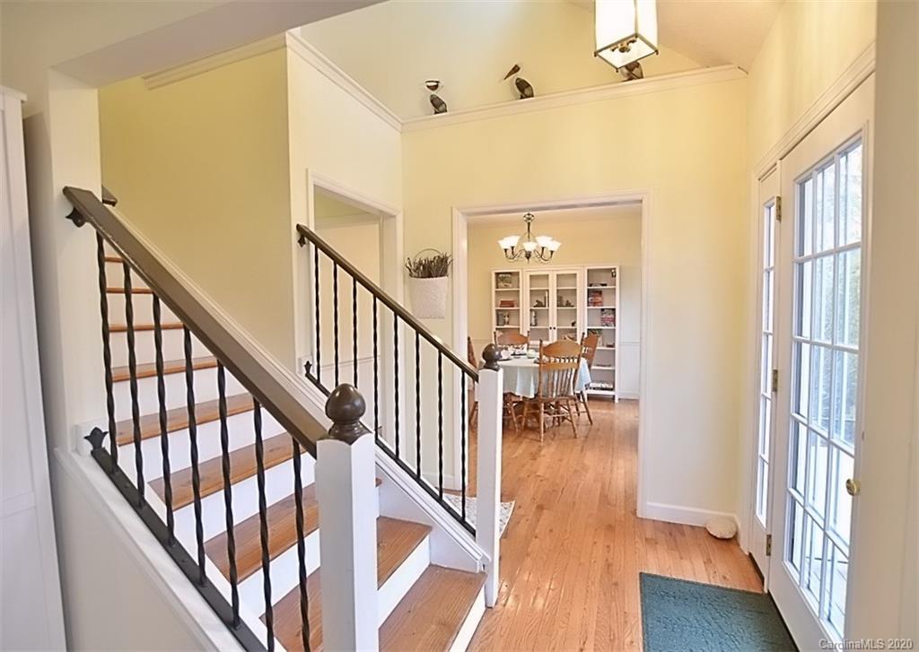 11068 Deep Cove Drive Tega Cay, SC 29708 - Photo 4 of 34 a view of staircase with lots of frames on wall and wooden floor