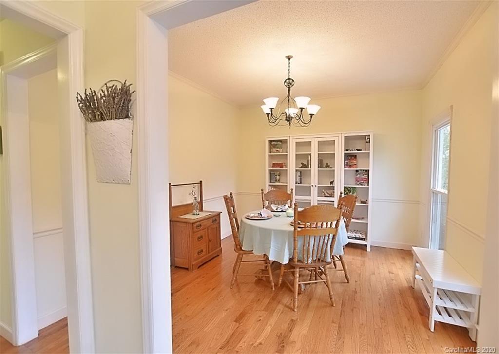 11068 Deep Cove Drive Tega Cay, SC 29708 - Photo 7 of 34 a view of a dining room with furniture a chandelier and wooden floor