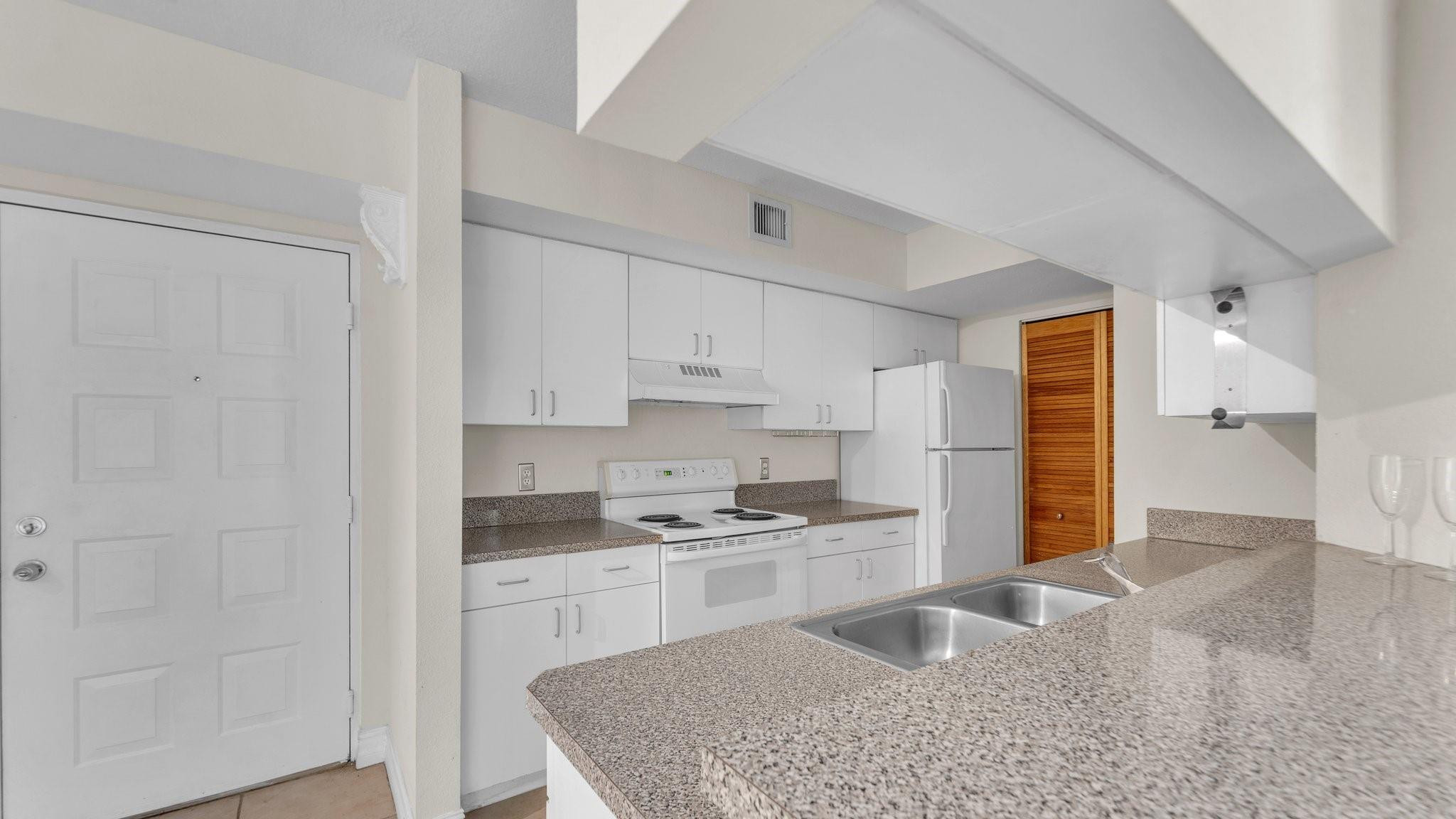 430 South Park Road, Unit 3303 Hollywood, FL 33021 - Photo 7 of 27 a kitchen with granite countertop a sink stove and refrigerator
