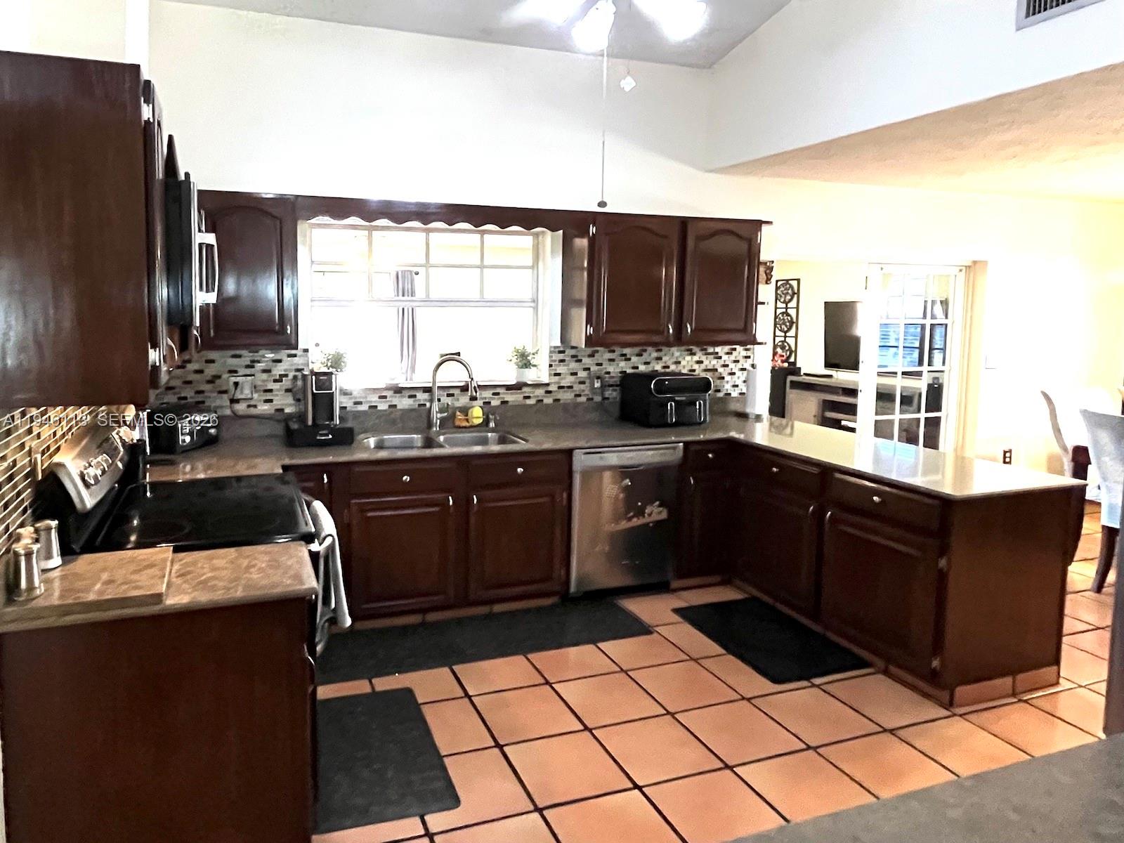 16200 Southwest 284th Street Homestead, FL 33033 - Photo 6 of 23 a kitchen with a sink a stove and a refrigerator
