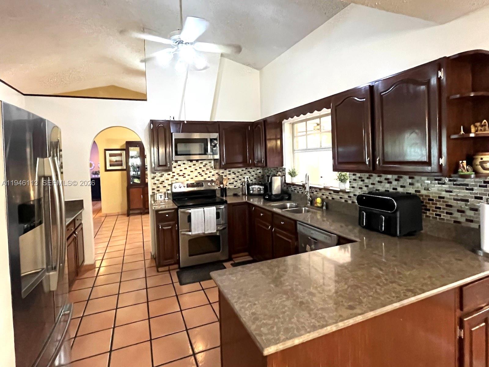16200 Southwest 284th Street Homestead, FL 33033 - Photo 7 of 23 a kitchen with stainless steel appliances granite countertop a stove a sink and a microwave