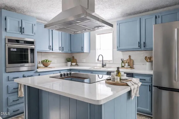 a kitchen with stainless steel appliances granite countertop a sink stove a refrigerator and cabinets with wooden floor