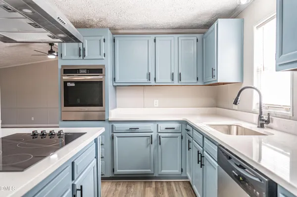 a kitchen with a sink stove top oven and cabinets