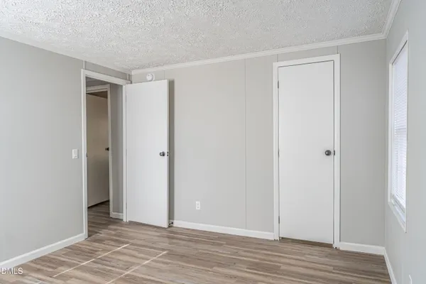 a view of an empty room with wooden floor
