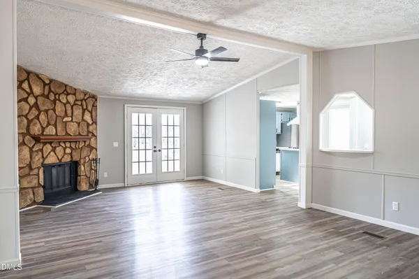 a view of an empty room with window and wooden floor