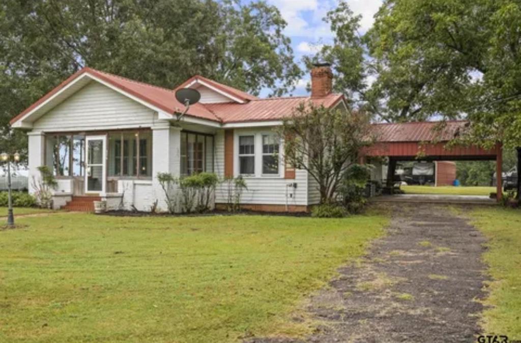 304 Daingerfield Street Naples, TX 75568 - Photo 2 of 25 a front view of a house with a garden and porch