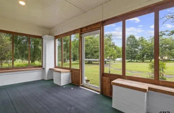 wooden floor fireplace and windows in an empty room