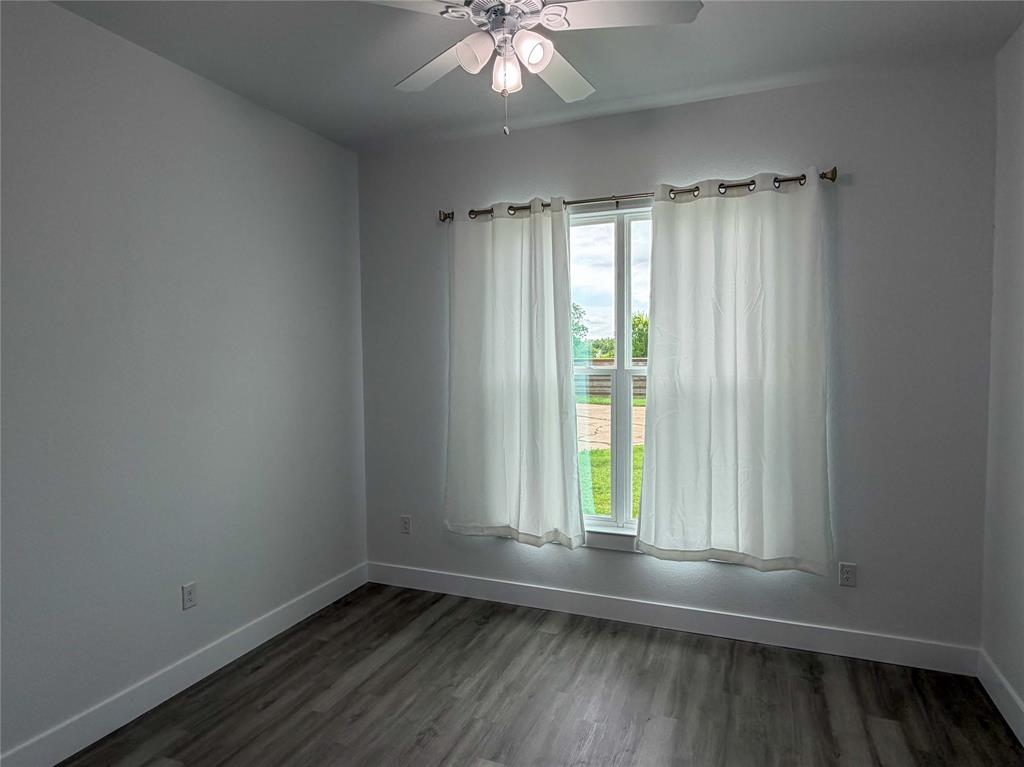 4200 Williams Road Bellmead, TX 76705 - Photo 13 of 22 an empty room with wooden floor and windows
