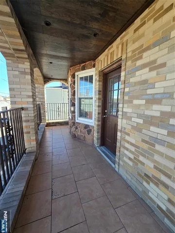 a view of a porch with wooden floor and iron stairs