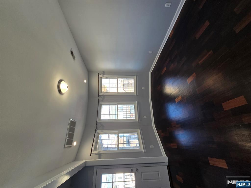 124 Devon Terrace, Unit SECOND Kearny, NJ 07032 - Photo 3 of 12 an empty room with wooden floor and windows