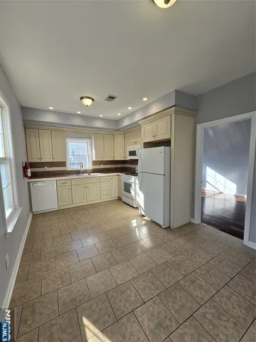 a view of a kitchen with a sink and an open refrigerator