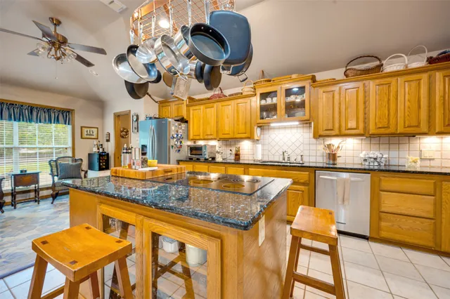 a kitchen with stainless steel appliances granite countertop a sink a stove and cabinets