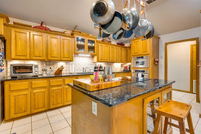 a kitchen with stainless steel appliances granite countertop a sink and cabinets