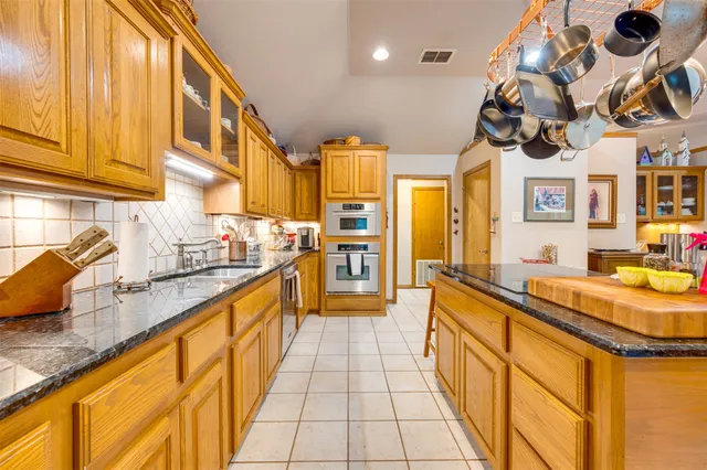 a large kitchen with stainless steel appliances granite countertop a sink and cabinets