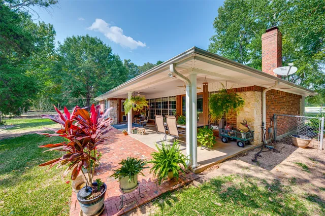 a view of a house with backyard sitting area and garden