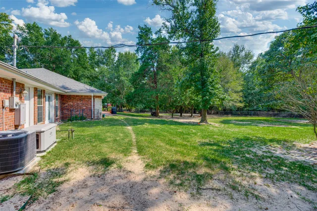 a view of a house with backyard and a tree