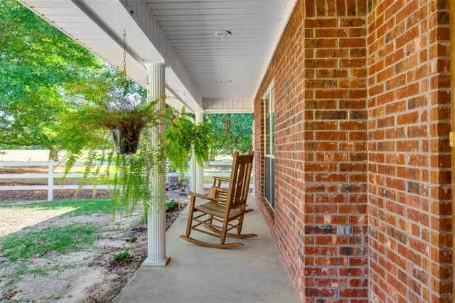 a view of a patio with a table and chairs and potted plants